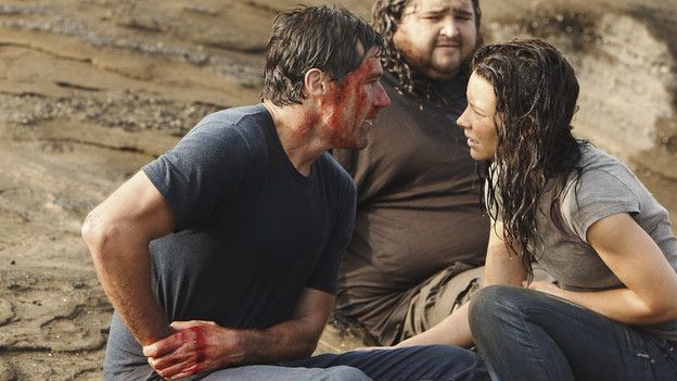 Jack and Kate sitting on the ground, with Hurley sitting behind them, watching. Jack is bloody and is holding his side, Kate looks concerned.