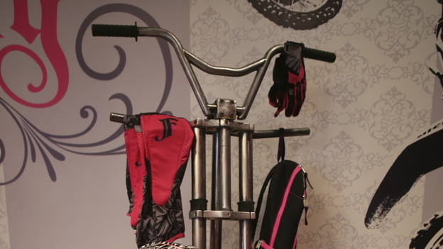 Paige's Bicycle Coat RackMaterials:- Drill- Grinder- Metal cutting saw- WelderTools Needed:- 24" Bicycle Tire- 6' 2" black iron pipe- Old bicycle- 3/8" steel rod- Satin clear coat (spray)Procedure    Weld the black iron pipe to the center hub of the bicycle tire.  Make sure that it is 90 degrees from the ground.    Take the bicycle apart.  Grind and clean all bicycle parts.  The top portion of the coat rack is made with handle bars.  Weld or bolt the handle bars to the top of the pipe, about five and a half feet from the floor.    Decide what parts you want to attach to the main shaft of the rack.  We used the bike body and lower handle bar assembly.  Bolt or weld the parts to the pipe.    Make sure the pipe is ridged with the base.  If needed, make forty five degree supports out of the 3/8" rod.  They are attached about two feet above the floor on the pipe.  The bottoms of the supports attach to the rim of the tire base.    Add any extra parts that you would like along the body of the coat rack.    Once assembled, the whole rack should be sprayed with a satin clear coat.   