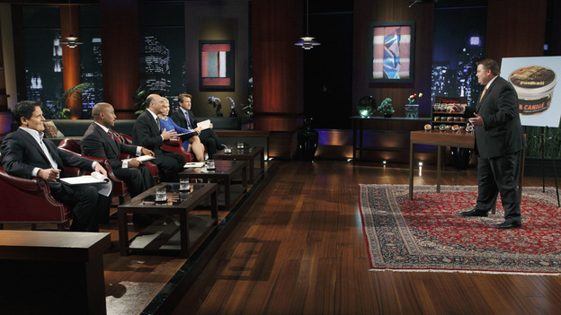 SHARK TANK -"Episode 204" -- Tempers flare when guest Shark Mark Cuban urges the entrepreneurs to stop negotiating with the other Sharks if they even want a chance to make a business deal with him. In this episode, a fireman from Arkansas brings an invention to the Shark Tank that could make millions and save lives; after creating an eco-friendly way to listen to music on the go, a duo from Chicago hope the Sharks will want to invest; a feisty, combative entrepreneur from Montclair, New Jersey seeks to cash in on the lucrative wedding business; and a man from Oklahoma hopes the Sharks will smell the money when he pitches his unique male-oriented brand of candles, on "Shark Tank," FRIDAY, MAY 6 (8:00-9:00 p.m., ET) on the ABC Television Network. (ABC/CRAIG SJODIN)MARK CUBAN, DAYMOND JOHN, KEVIN O'LEARY, BARBARA CORCORAN, ROBERT HERJAVEC, JOHNSON BAILEY (MAN CANDLE)