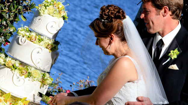 Melissa and Larry cut into a beautiful 3-tier cake at Picture Point outside Disney&acirc;��s Wedding Pavilion. www.disneyweddings.com